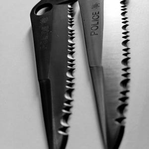 May include: Two black serrated knives with the word "Police" engraved on the blades.