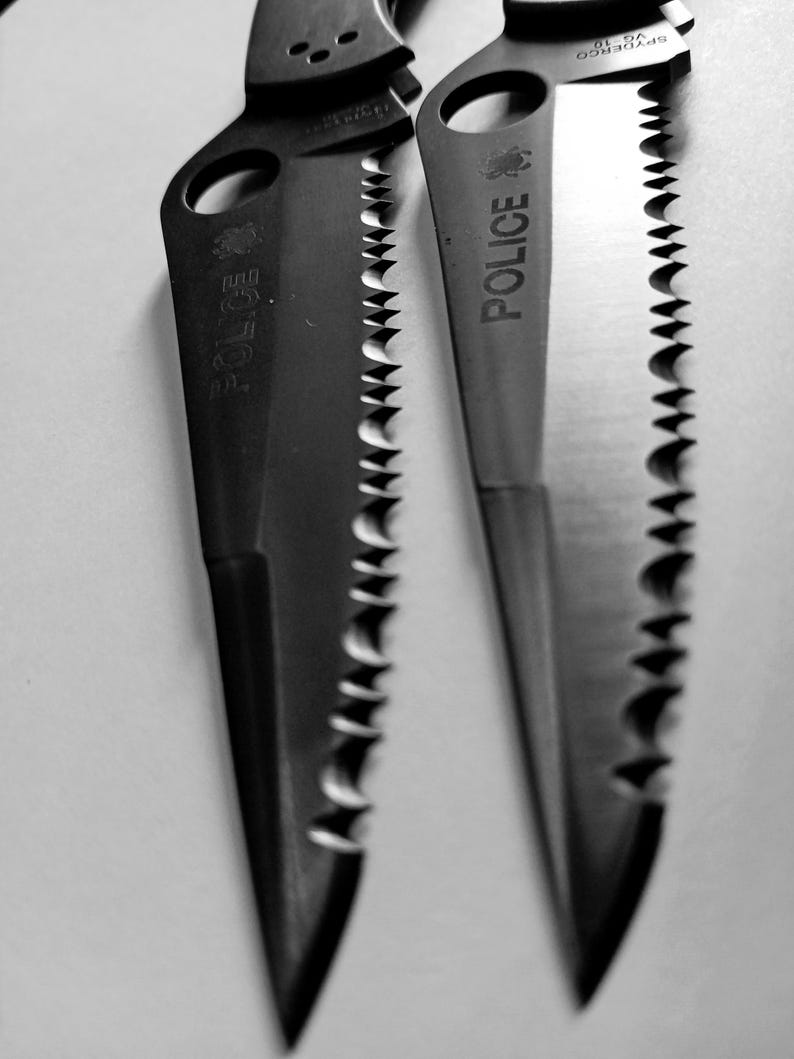 May include: Two black serrated knives with the word "Police" engraved on the blades.
