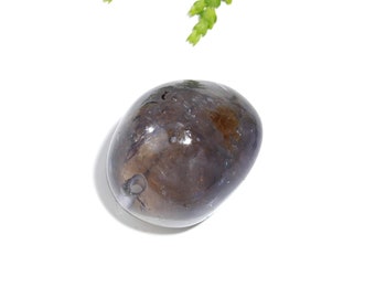 May include: A smooth, oval-shaped, dark gray gemstone with a small hole drilled through it. The stone has a translucent quality and appears to have some internal inclusions.