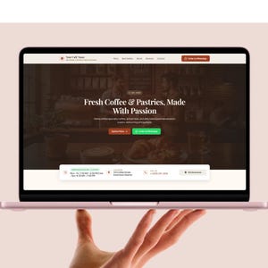 May include: A laptop screen displaying a website for a cafe named Your Cafe Name. The homepage features the text Fresh Coffee & Pastries, Made With Passion, navigation links, buttons for ordering via WhatsApp, and business hours and location details.
