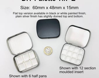 May include: A DIY Palette Tin 'E' measuring 60mm x 48mm x 15mm. The set includes a closed black tin, an open silver tin with six white half pans, and an open silver tin with a twelve-section white molded insert, alongside a one-pound coin.