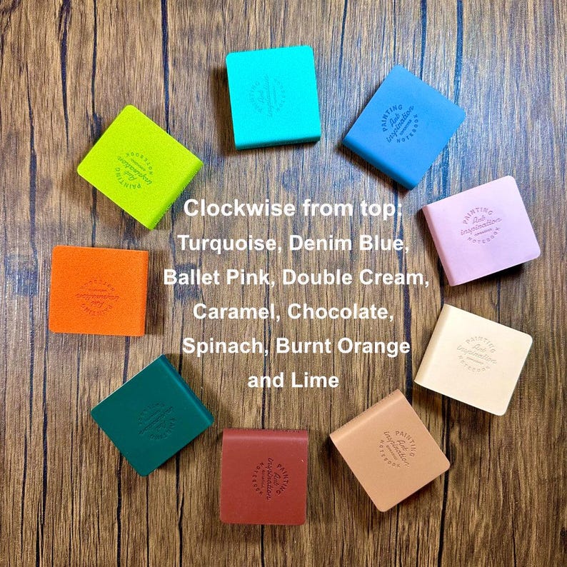 May include: Ten square notebooks arranged in a circle, featuring colors including turquoise, denim blue, ballet pink, double cream, caramel, chocolate, spinach, burnt orange, and lime. Each notebook cover is embossed with the text Painting Art Inspiration.