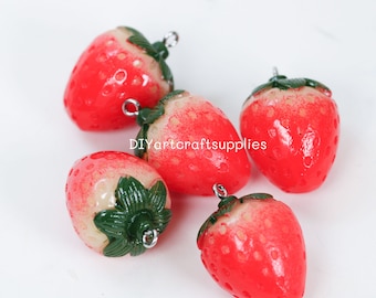 Può includere: Cinque ciondoli a forma di fragola rossi e bianchi con foglie verdi e anelli di salto argentati. I ciondoli sono in pasta polimerica e misurano circa 2,5 cm.