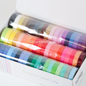 May include: A box of colorful washi tape rolls, arranged in a rainbow pattern. The box is white with the text "Colorful your life" and "Rainbow" printed on it. The text "DIYartcraftsupplies" is printed on the plastic wrap covering the rolls.