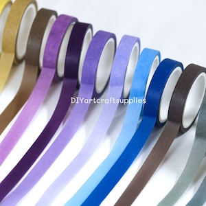 May include: A set of ten washi tapes in a gradient of colors, starting with gold and transitioning to gray. The tapes are arranged in a row, with the gold tape at the top and the gray tape at the bottom. The tapes are all the same width and have a matte finish.