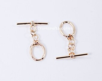 May include: Two gold-toned metal toggle clasps with a chain and a ring. The clasps are used for jewellery making and crafting.
