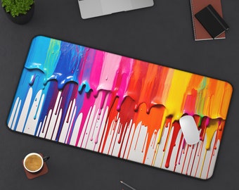 Op de afbeelding: Een muismat met een kleurrijk abstract ontwerp, met strepen verf die over een witte achtergrond druppelen. De kleuren omvatten rood, oranje, geel, groen, blauw, paars en roze.