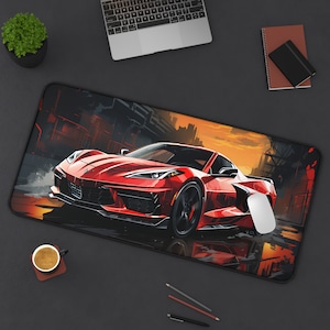 May include: A red sports car with black accents is driving on a city street. The car is surrounded by buildings and a sunset sky. The car has a black mouse pad on the ground.