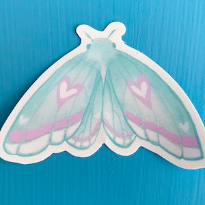 May include: A sticker of a light blue butterfly with pink hearts on its wings.