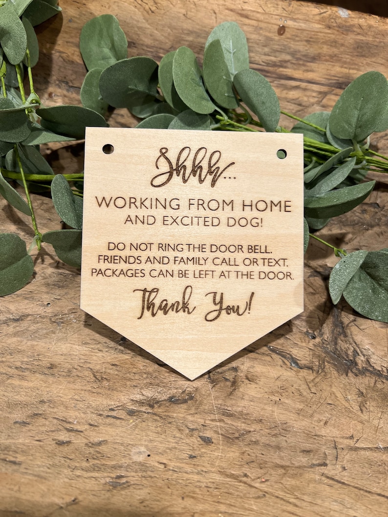 May include: A wooden sign with the text "Shhh... Working from home and excited dog! Do not ring the door bell. Friends and family call or text. Packages can be left at the door. Thank you!"