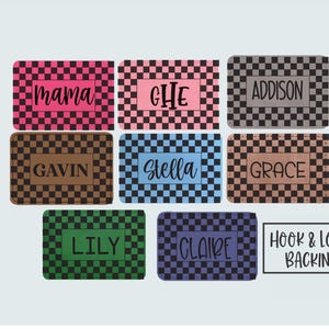 May include: A collection of personalized rectangular patches with hook and loop backing. Each patch features a checkered pattern in various colors, with names like "mama," "Gavin," and "Addison" displayed in a contrasting font. The text "HOOK & LOOP BACKING" is also visible.