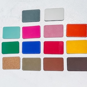 May include: A collection of rectangular patches in various colors, including gray, white, teal, pink, orange, green, blue, red, yellow, cork, olive, brown, and dark brown. Each patch has a stitched border, offering a handcrafted appearance.