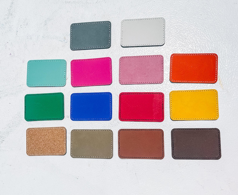 May include: A collection of rectangular patches in various colors, including gray, white, teal, pink, orange, green, blue, red, yellow, cork, olive, brown, and dark brown. Each patch has a stitched border, offering a handcrafted appearance.