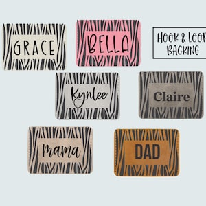 May include: Rectangular patches with zebra print borders and various names in white or black font. Names include Grace, Bella, Kynlee, Claire, Mama, and Dad. The text "Hook & Loop Backing" is also present.