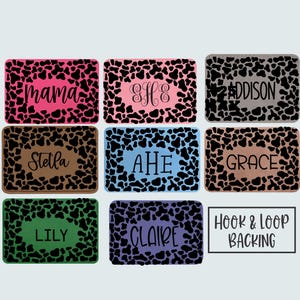 May include: Rectangular patches with a cow print border and various names in cursive font. The patches feature different background colors, including pink, brown, blue, and green. The text "Hook & Loop Backing" is also visible.