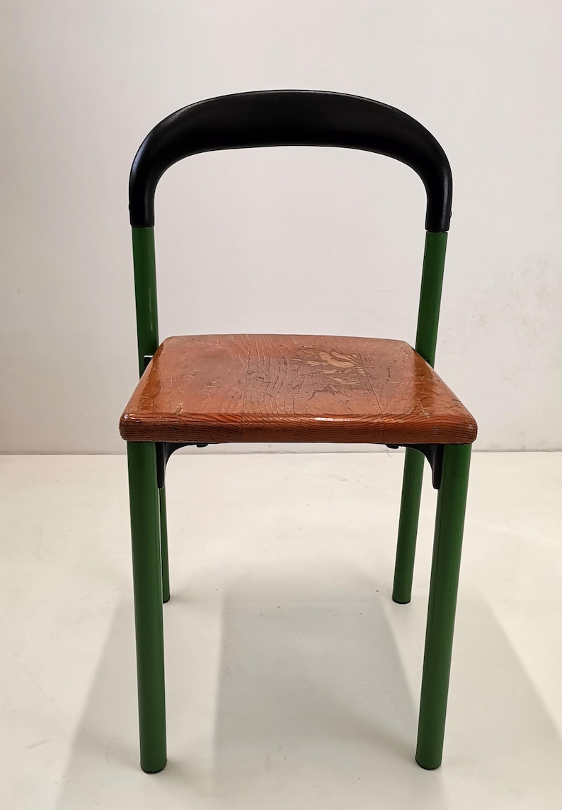 May include: A green metal chair with a black padded back and a wooden seat.