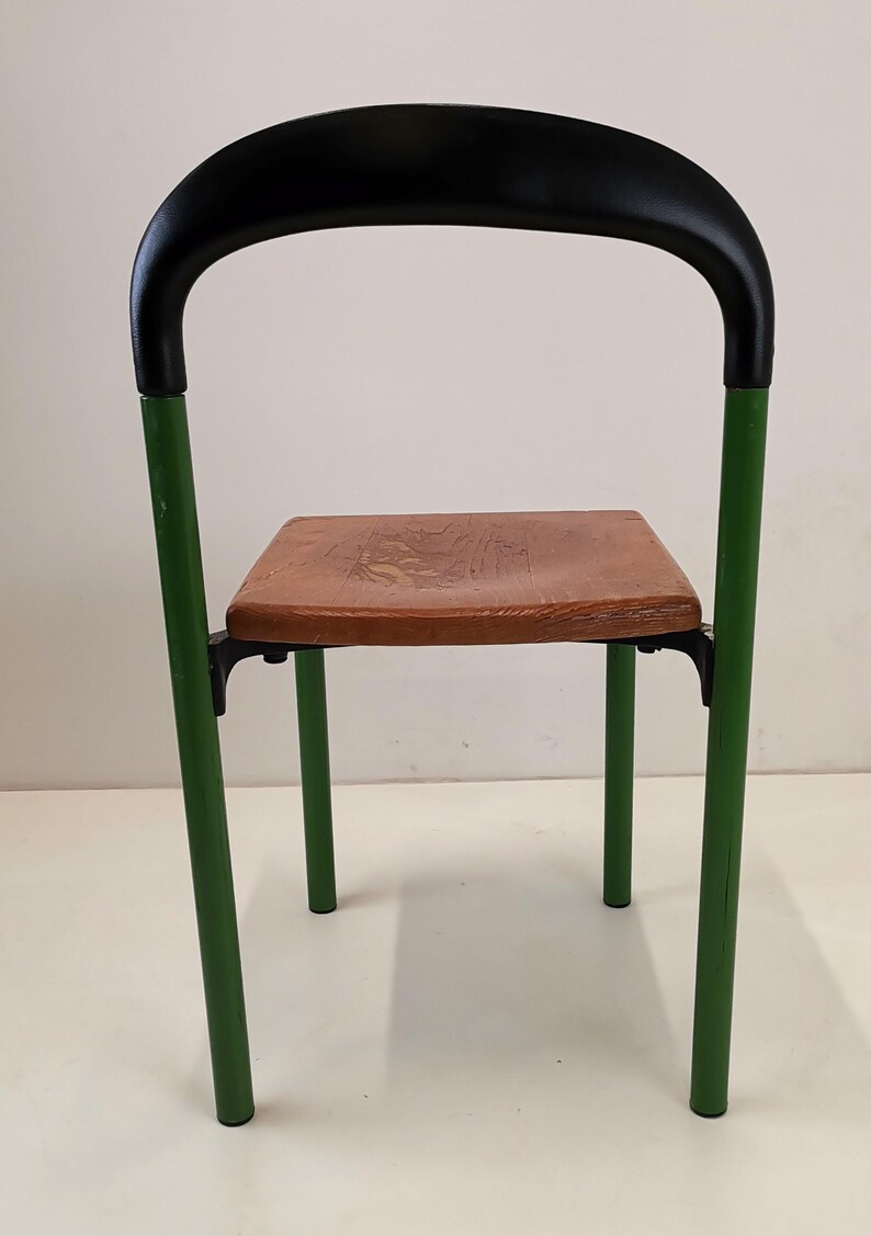 May include: A green metal chair with a black padded back and a wooden seat.