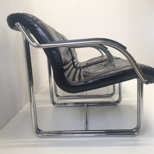 1 van 2 verchroomde buisstoelen / ontworpen jaren 60 / roestvrijstalen frame / zwart gelakte houten armen en zwartleren bekleding