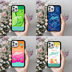 May include: Four phone cases with black borders, each featuring a different design. The cases display the "Alani" logo with flavor names like "Lime Slush," "Blueberry," "Orange Kiss," and "Tropsicle." The cases are held in front of a floral background.