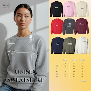 Op de afbeelding: Een lichtgrijs unisex sweatshirt met de tekst "UNISEX SWEATSHIRT". De afbeelding toont ook sweatshirts in verschillende kleuren, waaronder zwart, rood en marine, met afmetingen in inches.