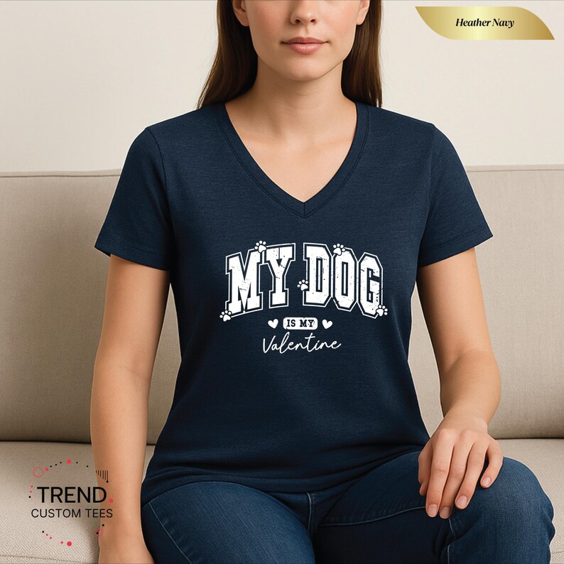 May include: Heather navy V-neck t-shirt with the text "MY DOG is my Valentine" in white. The shirt features paw prints and hearts. The shirt is made of a soft material.