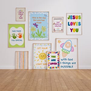 Può includere: Una collezione di stampe artistiche incorniciate con messaggi stimolanti e illustrazioni colorate. Le stampe presentano frasi come "Gesù ti ama", "Dio ti ha reso speciale" e "Sei amato". L'opera d'arte include un razzo, un sole e impronte di mani.