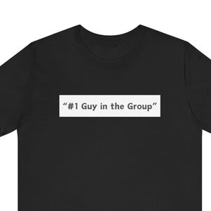 May include: Black t-shirt with the text "#1 Guy in the Group" in a white rectangular box. The shirt is a short-sleeved crew neck style, suitable for casual wear. The text is centered on the chest.