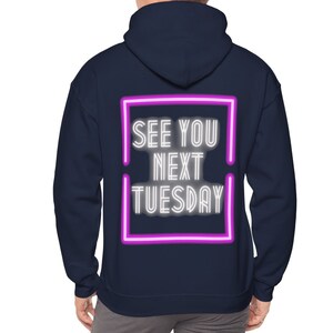 Könnte beinhalten: Marineblauer Kapuzenpullover mit einem weißen Neon-Schriftzug, der "See You Next Tuesday" in einem rosafarbenen Rahmen zeigt.