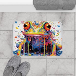 May include: A colorful bath mat with a psychedelic frog design. The frog is dripping with rainbow colors and is surrounded by colorful paint splatters.