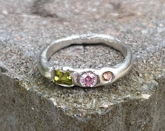 Anel de prata com pedras de peridoto, rosa e champanhe.