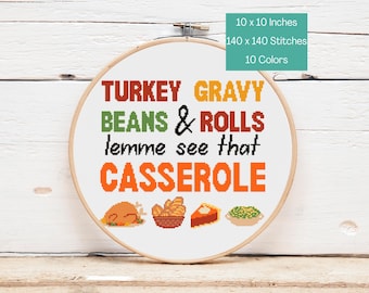 May include: A cross-stitch embroidery hoop with the words "TURKEY GRAVY BEANS & ROLLS lemme see that CASSEROLE" in various colors. The design includes images of a turkey, rolls, pie, and green beans. The hoop is 10 x 10 inches.