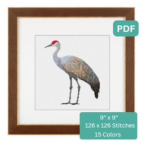 May include: A cross-stitch pattern of a gray sandhill crane with a red crown, standing on a white background. The pattern is 9 inches by 9 inches and uses 126 by 126 stitches with 15 colors.