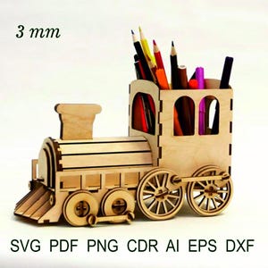 以下が含まれることがあります： 木製の電車型卓上オーガナイザー、厚さ3mm。様々な色の鉛筆やペンが入っています。デザインには車輪、煙突、詳細な前面が含まれています。画像の下部には「SVG PDF PNG CDR AI EPS DXF」というテキストがあります。