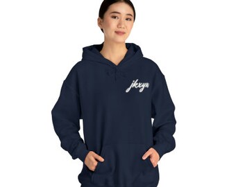 Può includere: Una felpa con cappuccio blu navy con una grafica bianca che dice "jkxyn" sul petto sinistro.