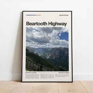 Op de afbeelding: Een ingelijste verticale poster met een foto van de Beartooth Highway in de Verenigde Staten. De print toont de tekst Beartooth Highway, Montana/Wyoming en beschrijvende alinea's op een crèmekleurige achtergrond met een zwarte lijst.