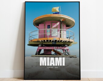 Puede incluir: Un puesto de salvavidas rosa y naranja en una playa con el texto "Miami Beach" y "Miami, Florida - USA".