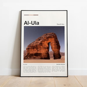 May include: A framed art print featuring a photograph of Al-Ula, Saudi Arabia. The image showcases a large, naturally formed rock arch in a desert landscape under a starry sky. The print includes the text "Al-Ula" and "Saudi Ara-".