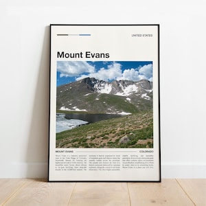 Könnte beinhalten: Ein gerahmtes Poster mit einer malerischen Ansicht des Mount Evans in Colorado, USA. Das Bild zeigt einen Berg mit Schnee, einen See und grüne Vegetation unter einem blauen Himmel mit Wolken. Das Poster trägt den Text "Mount Evans".