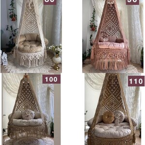 May include: Four macrame hanging chairs with fringe, each with a different cushion. The chairs are in various colors, including beige, brown, and pink. The chairs are hanging from the ceiling in a room with white walls.