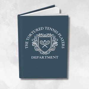 Puede incluir: Un libro azul oscuro con un escudo blanco que presenta dos raquetas de tenis cruzadas. El texto "The Tortured Tennis Players Department" rodea el escudo.