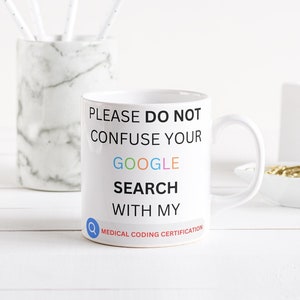 Könnte beinhalten: Eine weiße Keramiktasse mit dem Text "Bitte verwechseln Sie Ihre Google-Suche nicht mit meiner medizinischen Kodierungszertifizierung". Der Text "Google" ist in Regenbogenfarben. Die Tasse steht auf einer weißen Holzoberfläche.