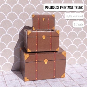 May include: Three brown paper dollhouse trunks with gold accents and brown straps. The trunks are stacked on top of each other. The image text reads "Dollhouse Printable Trunk", "Digital download", and "1:12 scale".