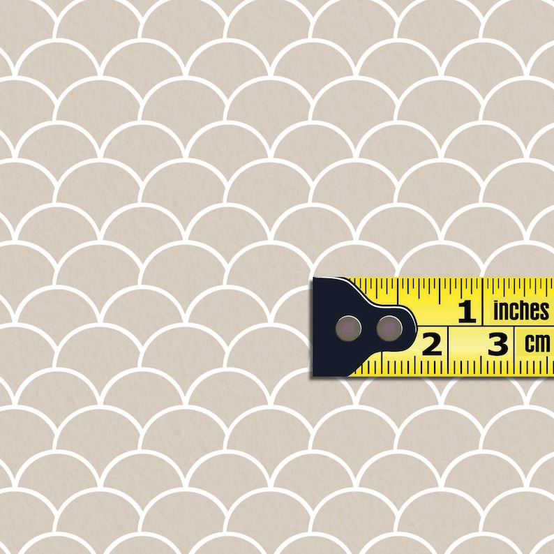 May include: A beige background with a white repeating pattern of overlapping half circles. A yellow measuring tape with black markings is placed on the pattern. The tape reads "1 inches" and "3 cm".