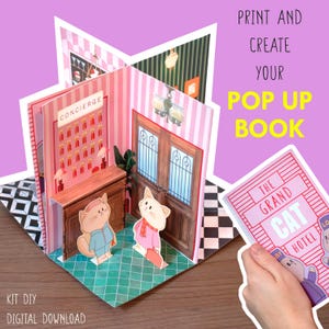 Op de afbeelding: Een doe-het-zelf pop-up boek kit met een kattenhotel thema. Het interieur toont een conciërgebalie, deuren en twee kattenpersonages. De boekcover leest "The Grand Cat Hotel". Tekst op de afbeelding zegt "Print and Create Your Pop Up Book".