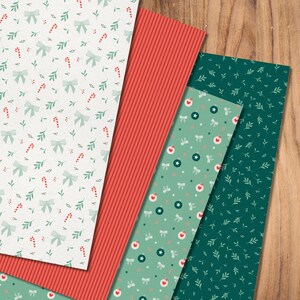 May include: Four sheets of wrapping paper with different Christmas patterns. One sheet is red, one is green with small leaves, one is green with white stars and bows, and one is white with green bows and red candy canes.