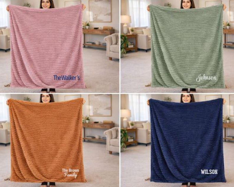 May include: Four plush blankets in different colors: dusty rose, sage green, burnt orange, and navy blue. Each blanket has a textured pattern and a personalized name or family name embroidered on it. The blankets are displayed in a well-lit room.