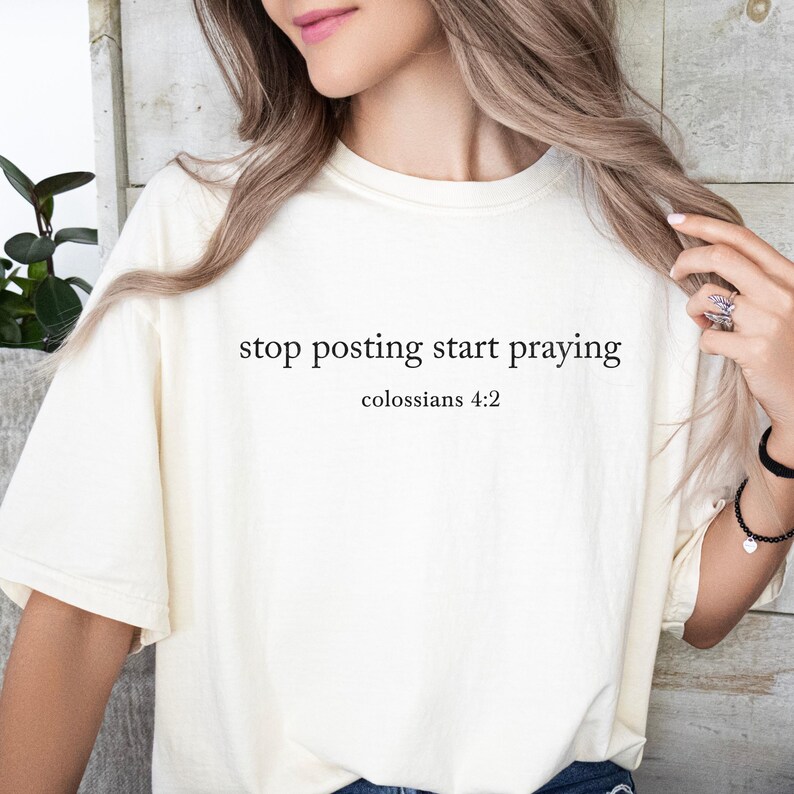 Puede incluir: Camiseta blanca con el texto "stop posting start praying" y "Colossians 4:2" impreso en ella.