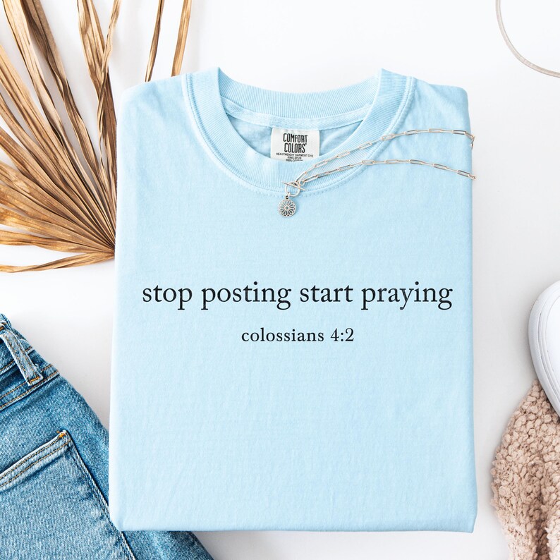 Puede incluir: Camiseta azul claro con el texto "stop posting start praying" y "colosenses 4:2" impreso en ella.