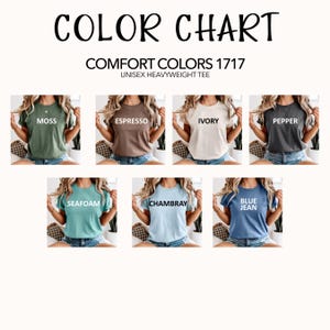 May include: A color chart for Comfort Colors 1717 unisex heavyweight t-shirts, displaying seven short-sleeve shirts in moss, espresso, ivory, pepper, seafoam, chambray, and blue jean colors, each labeled with its respective color name in white text.
