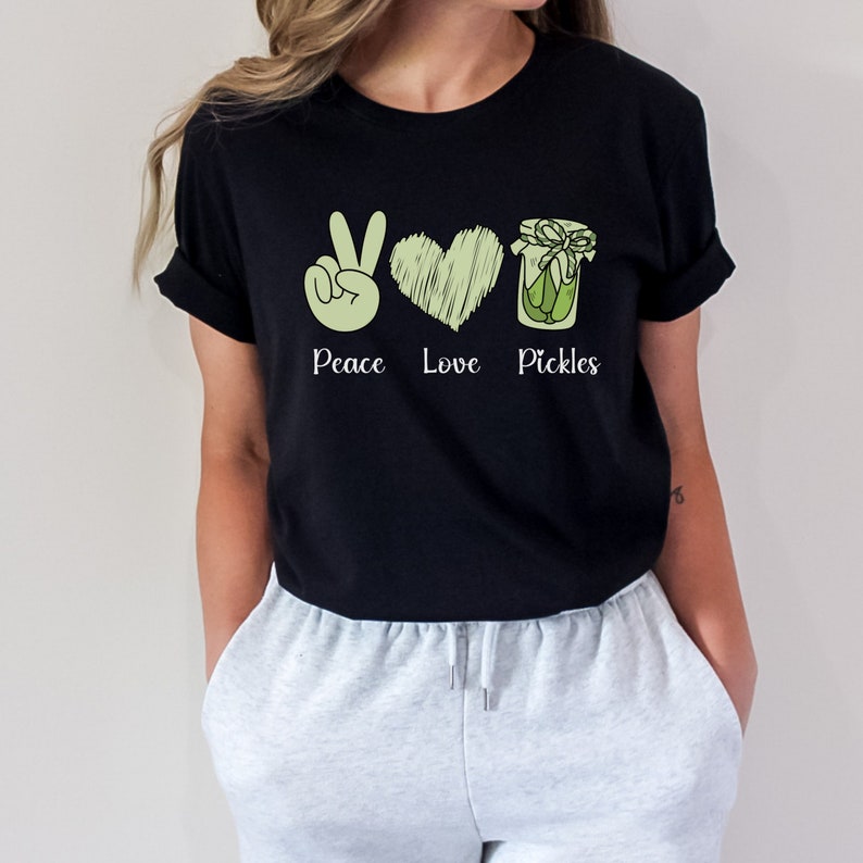 May include: Black t-shirt with a peace sign, heart, and jar of pickles graphic. The text "Peace Love Pickles" is printed below the graphic.